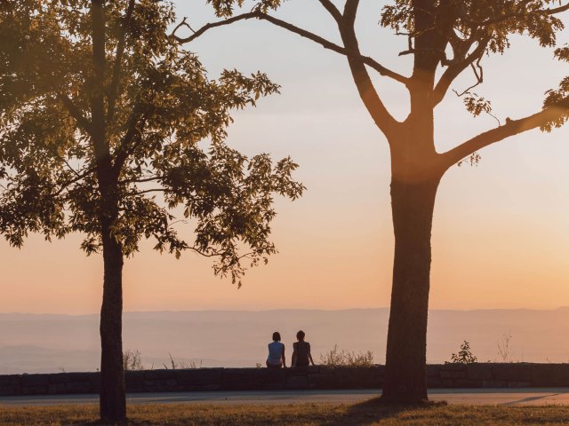 Two people admiring sunset view over mountains in Virginia