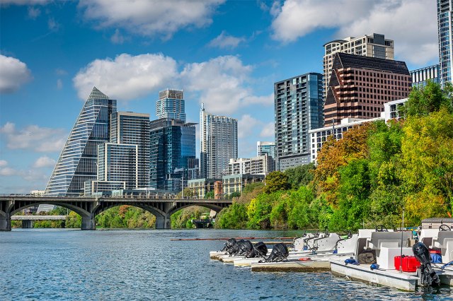 Paddle boats on Colorado River with Congress Avenue Bridge and Austin skyline in background