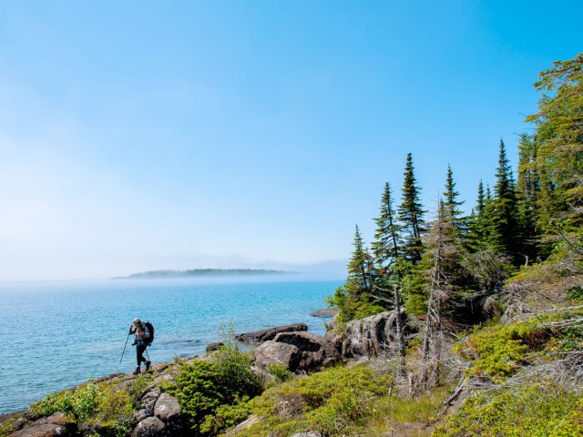 Hiker alongside water in Isle Royale National Park