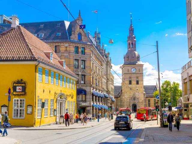 Clock tower and brightly painted buildings in downtown Oslo, Norway