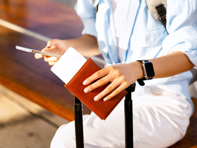 Traveler holding passport and phone