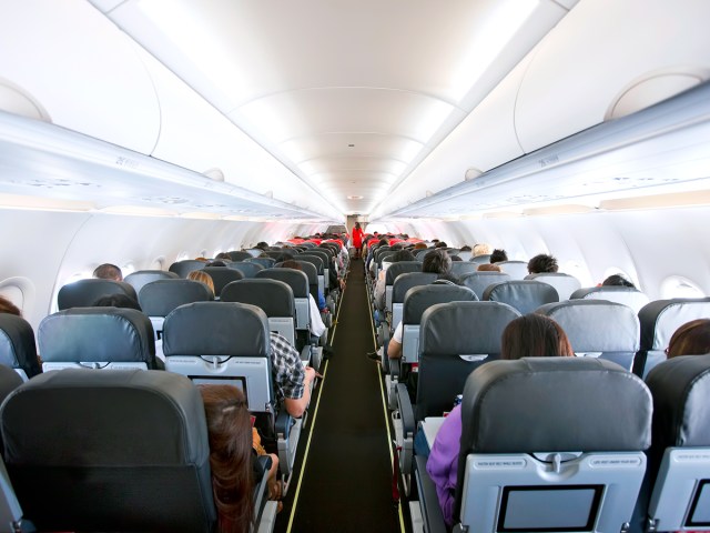 Image of single-aisle airplane cabin from rear